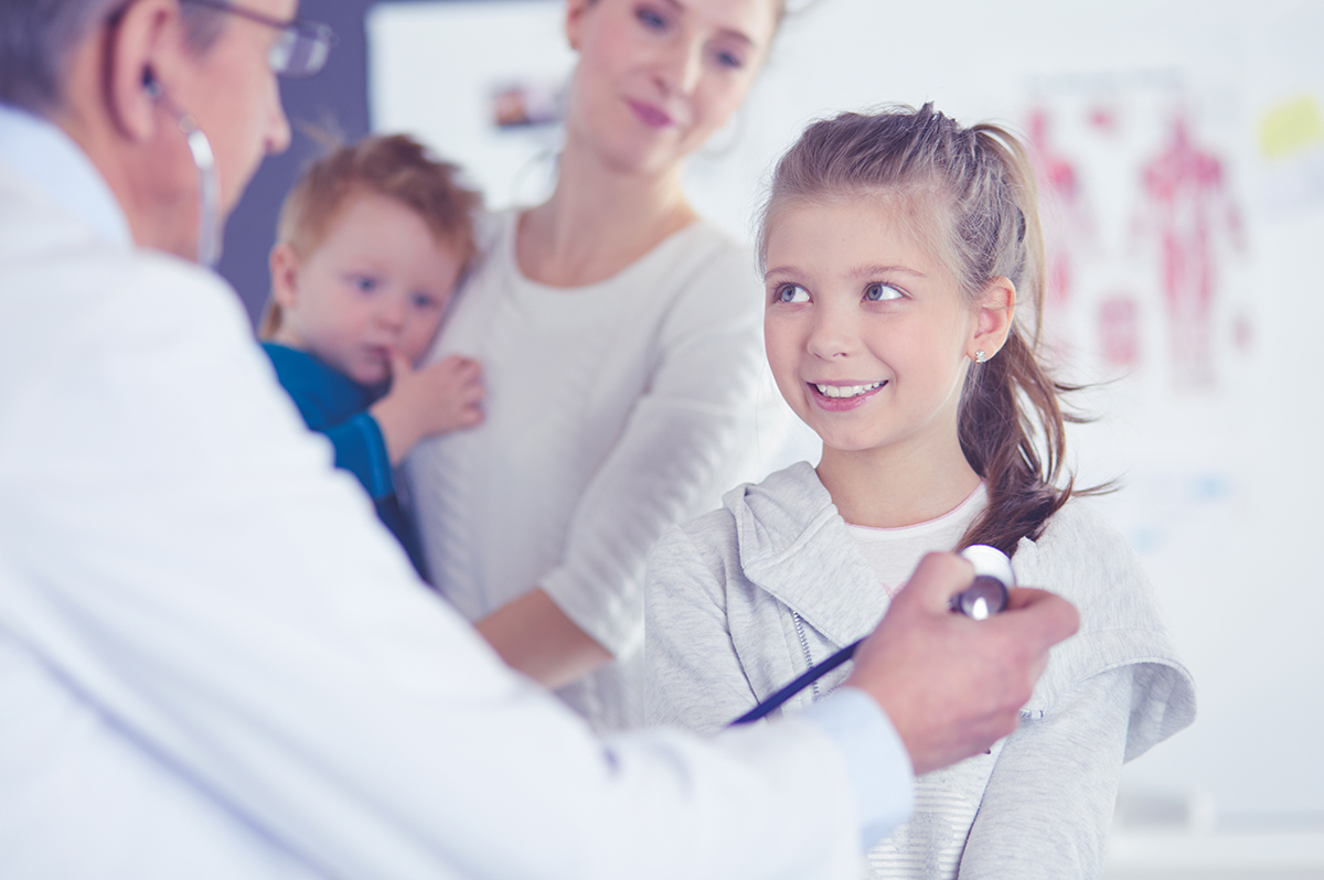 Doctor using a stethoscope to listen to a child’s heart.