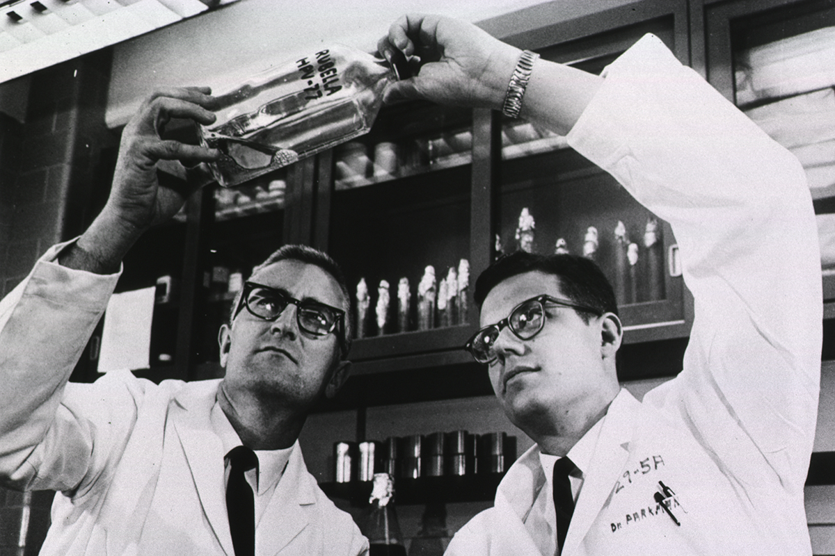 Two male scientists in the 1960s holding the Rubella vaccine