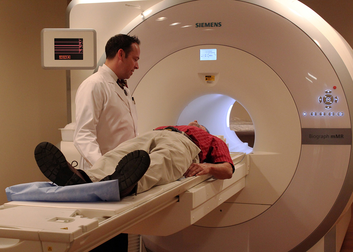 Imaging technologist talks to a patient before a scan in the fully integrated whole-body simultaneous PET/MRI device.