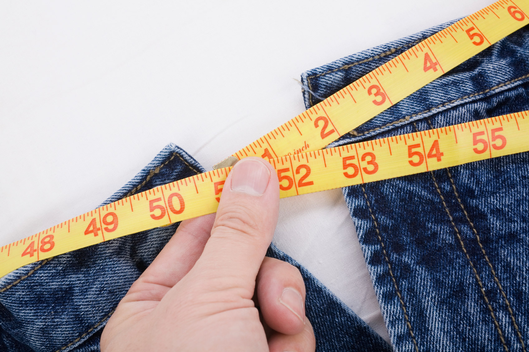 Photo of a person taking a waist measurement