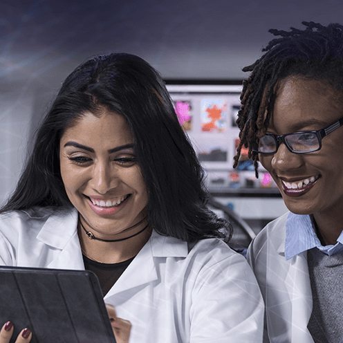 Two women researchers looking at a computer tablet.