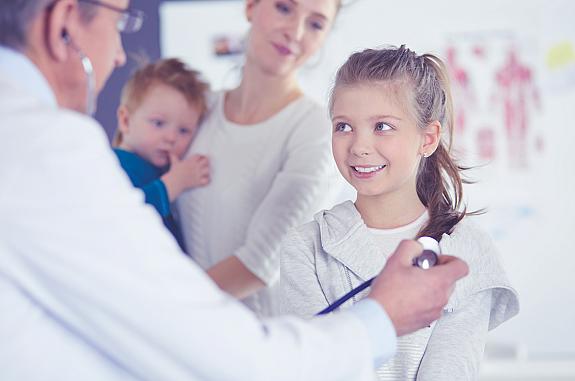 Doctor using a stethoscope to listen to a child’s heart.