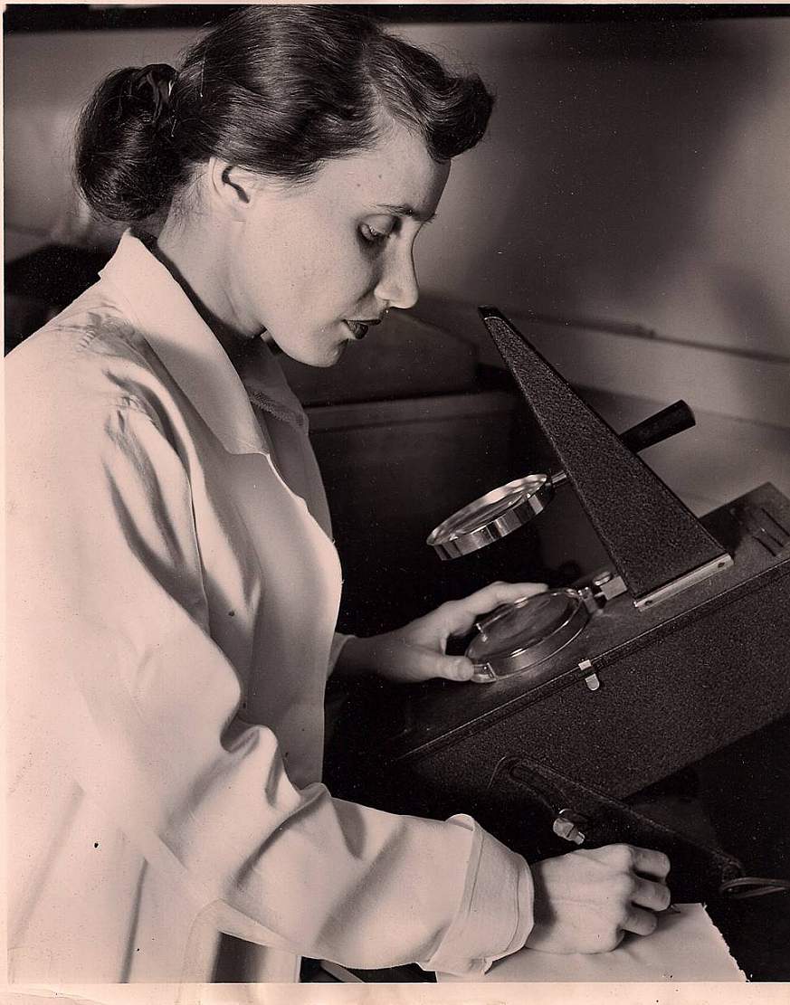 Ruth Kirschstein looking at a microscope.