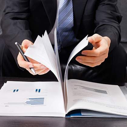 A business man flipping through a report A business man flipping through a report.