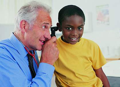 doctor examining a young boy's ear