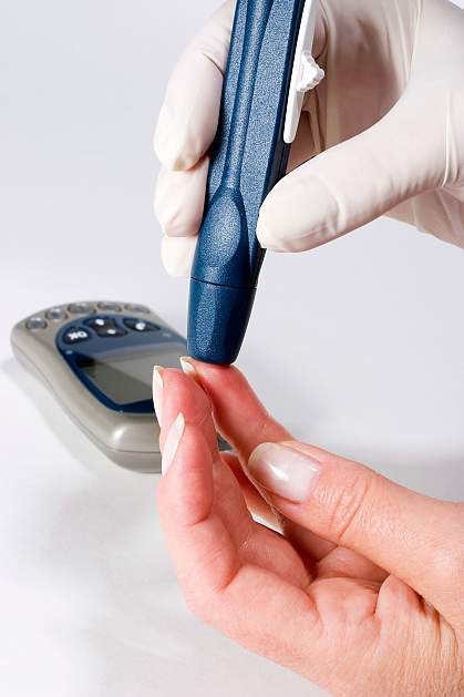 Photo of a person administering a blood glucose test Photo of a person administering a blood glucose test