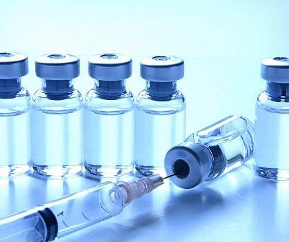 Photo of a line of medicine bottles with a syringe poking into the top of one Photo of a line of medicine bottles with a syringe poking into the top of one