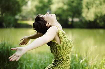 Photo of joyful young woman in meadow