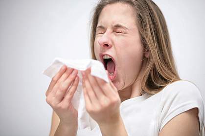 Photo of a young woman sneezing