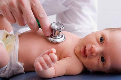 Photo of a doctor listening to an infant's chest with a stethoscope