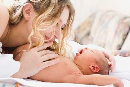 Photo of a mother admiring her yawning baby