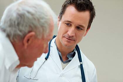 Photo of a physician talking with an older male patient