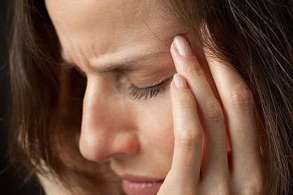 Woman with headache, massaging temples.