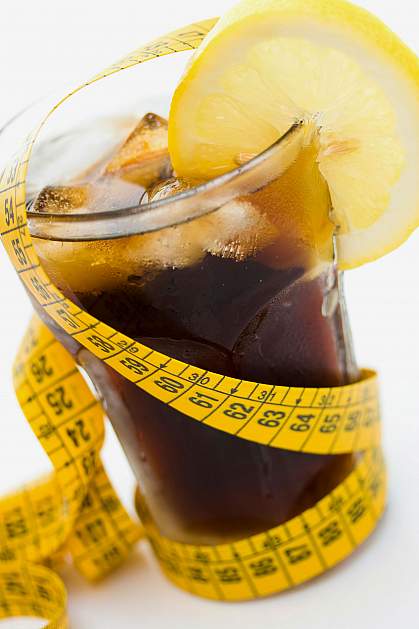 Glass of soda with a measuring tape wrapped around it.