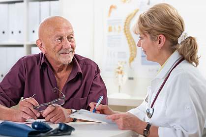 Older man talking to doctor.