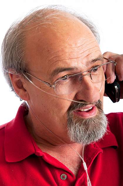 Man talking on the phone while receiving oxygen through a thin nasal tube.