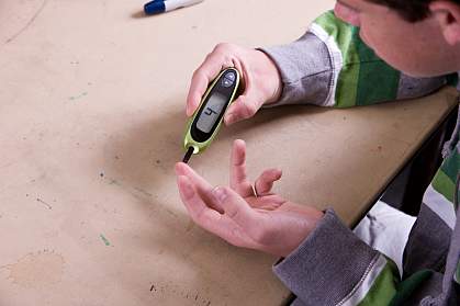 Teen boy checking blood sugar