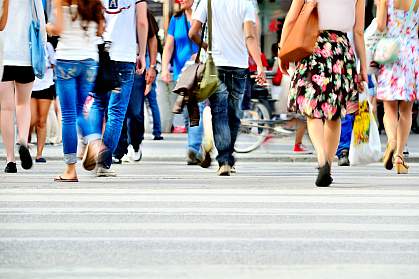 Blurred photo of pedestrians crossing a sunlit street