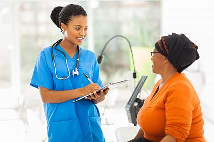 Nurse and senior patient, both African American