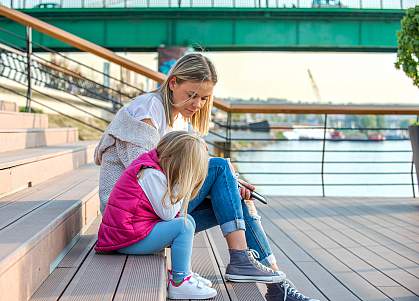 Mother and daughter sitting outside together on stairs Mother and daughter sitting outside together on stairs
