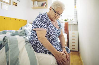 Senior woman holding her knee