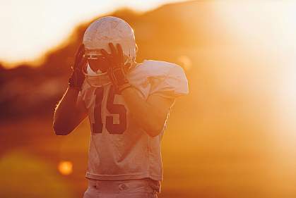 Football player holding helmet