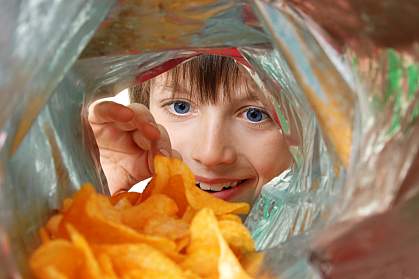 View from inside a potato chip bag of a boy enthusiastically looking in