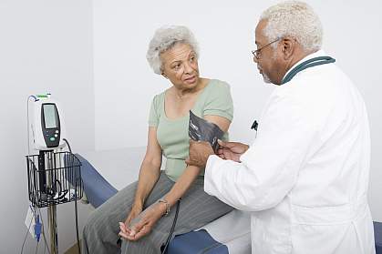 Doctor measuring blood pressure of senior Black woman Doctor measuring blood pressure of senior Black woman