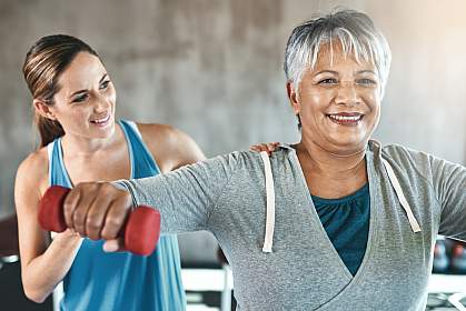 Older woman using weights with a physical therapist