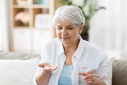 Senior woman taking pills with glass of water at home Senior woman taking pills with glass of water at home
