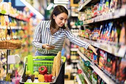 Woman selecting groceries from a shelf.