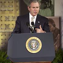 President George W. Bush standing at a podium.