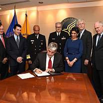 Acting Health and Human Services (HHS) Secretary Eric D. Hargan signs the declaration of a nationwide public health emergency on the opioid crisis, as requested by the President.  Standing from left to right: Assistant Secretary for Preparedness and Respo