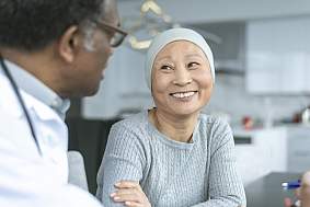 Beautiful Korean woman with cancer smiles at doctor