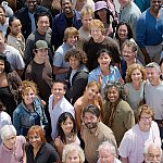 A crowd of happy people looking up at the camera.