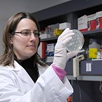 Researcher holding a petri dish.