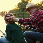 Man chatting with his grandson while fishing.