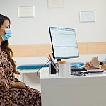 Image of a doctor and patient meeting at a desk.