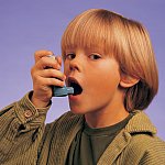 A young boy using an inhaler