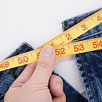 Photo of a person taking a waist measurement