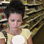 Woman reading a nutritional label.