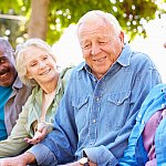 Group of older adults socializing outdoors.