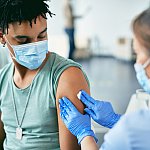 Young Black man getting vaccinated at vaccination center